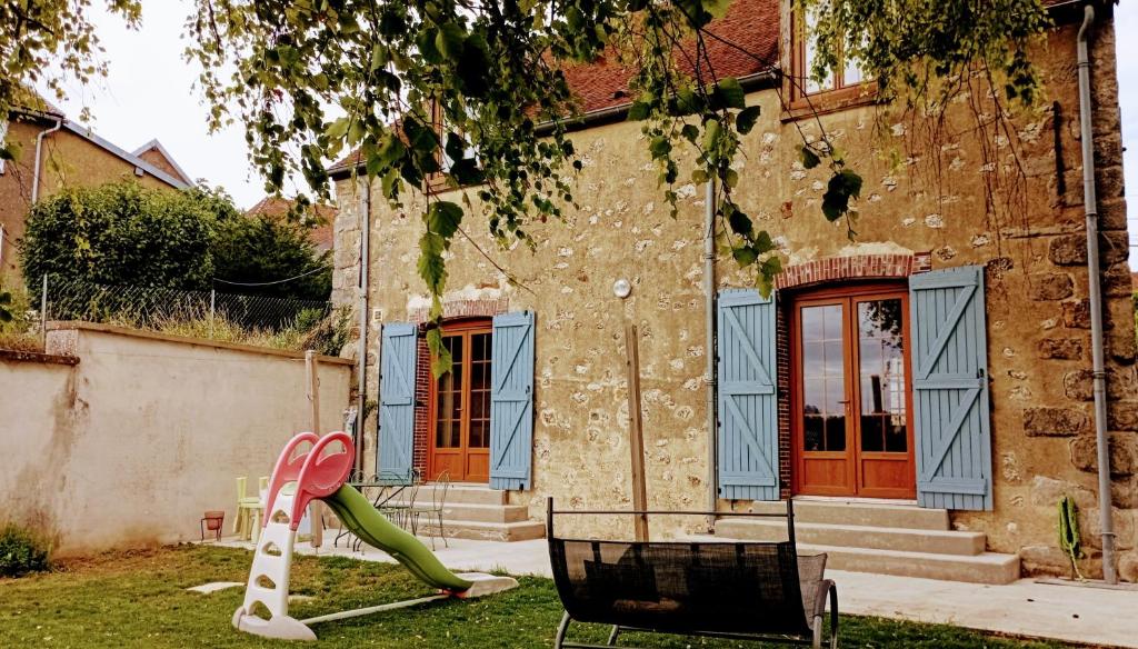 a playground in front of a house with a slide at Aux souvenirs d'Antan in Broyes