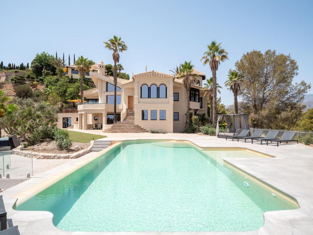 a large swimming pool in front of a house at Villa Rocca in La Herradura
