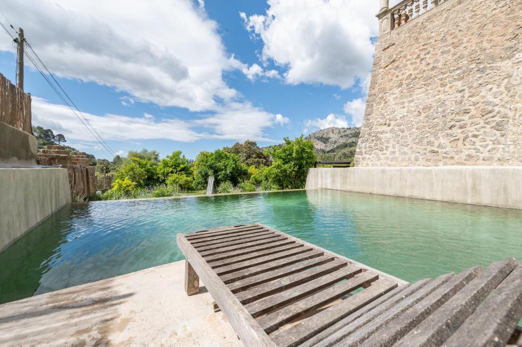 a bench sitting on the edge of a pool of water at ses llebres in Bunyola