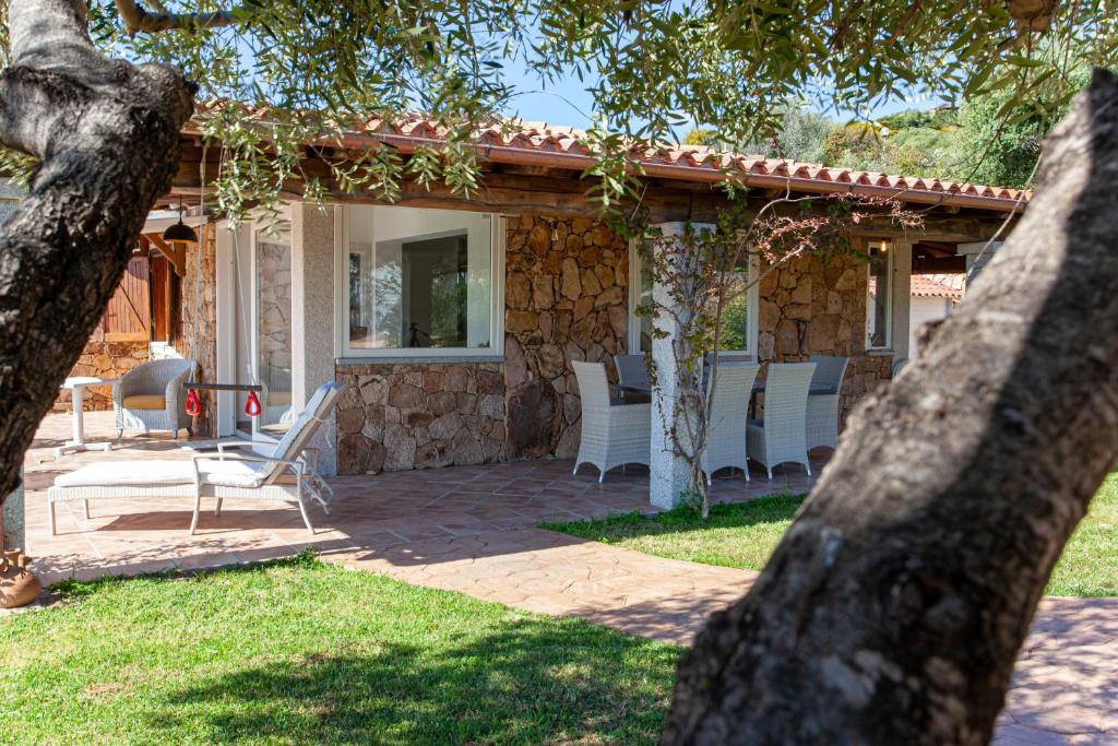 a house with white chairs on a patio at Risveglio con alba in San Teodoro