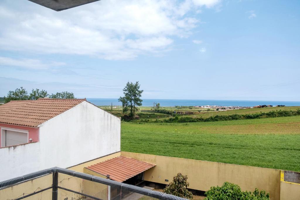 a view from a balcony of a house and a field at Casa da Orquidea in Ribeira Grande