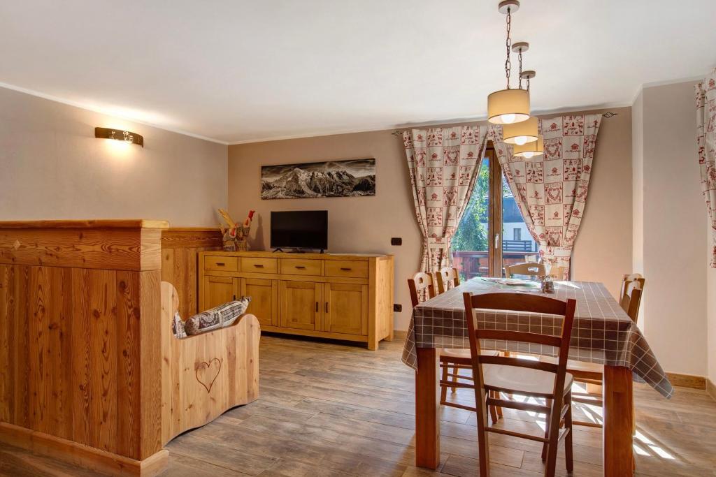 a dining room with a table and a tv at Torre St Orso 4061 Maison Gerard in Cogne