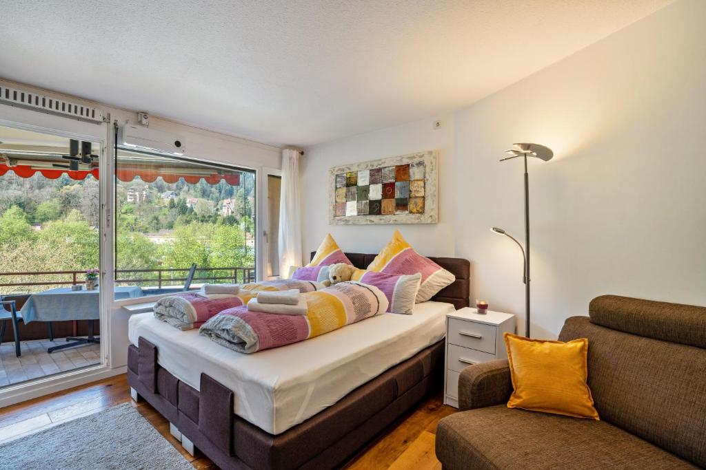 a bedroom with a bed and a couch and a window at Zentrale Ferienwohnung mit Balkon in Bad Liebenzell