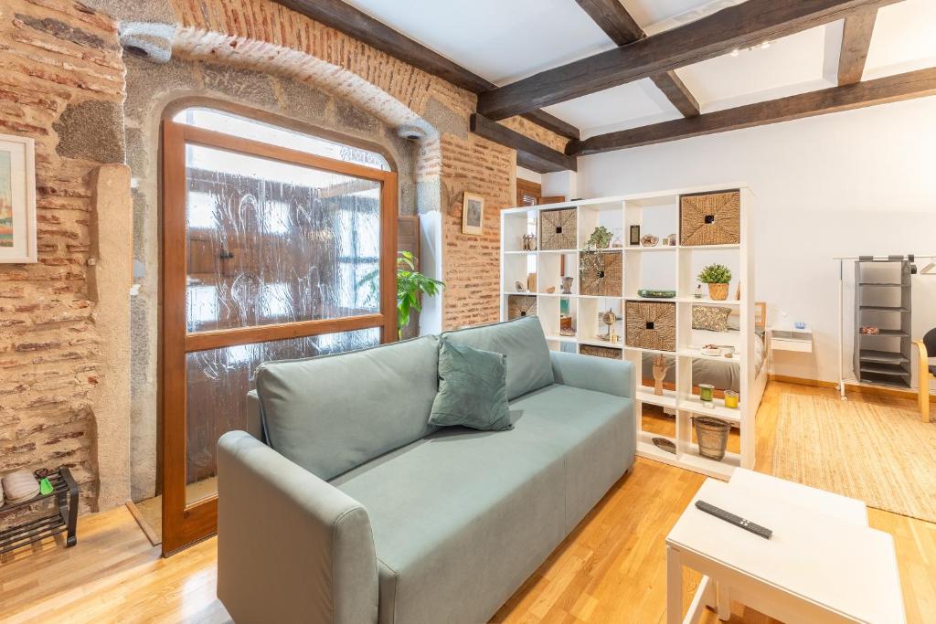 a living room with a couch and a window at Judería Apartamento in Segovia