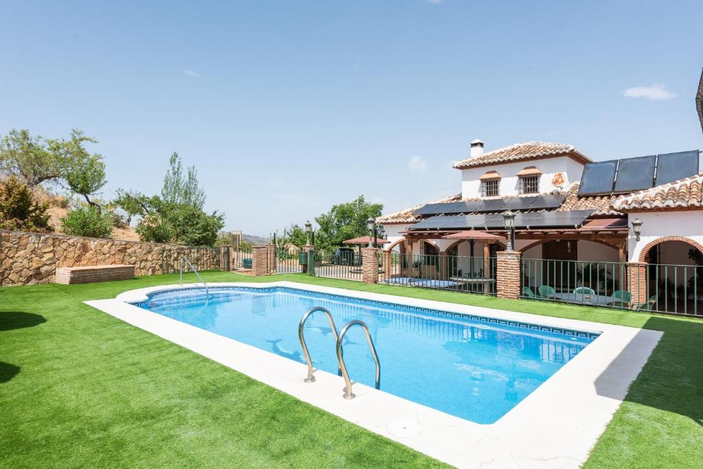 a swimming pool in the yard of a house at Mansión Piedras Blancas in Colmenar