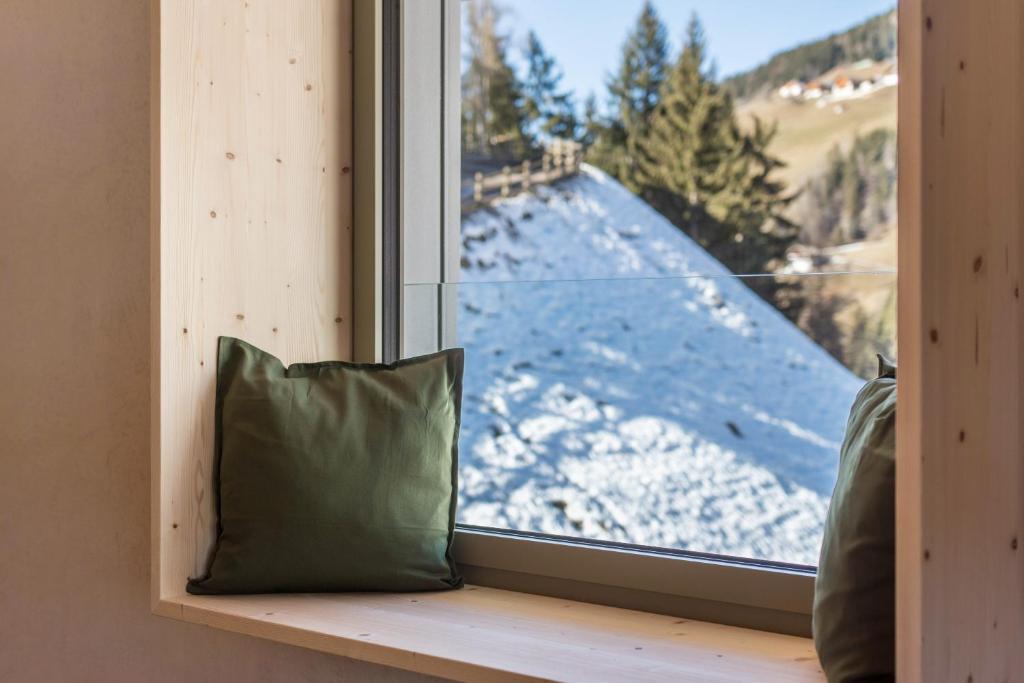 a pillow sitting on a window sill with a view at Lena Dolomites Luxury Suite in Villnoss