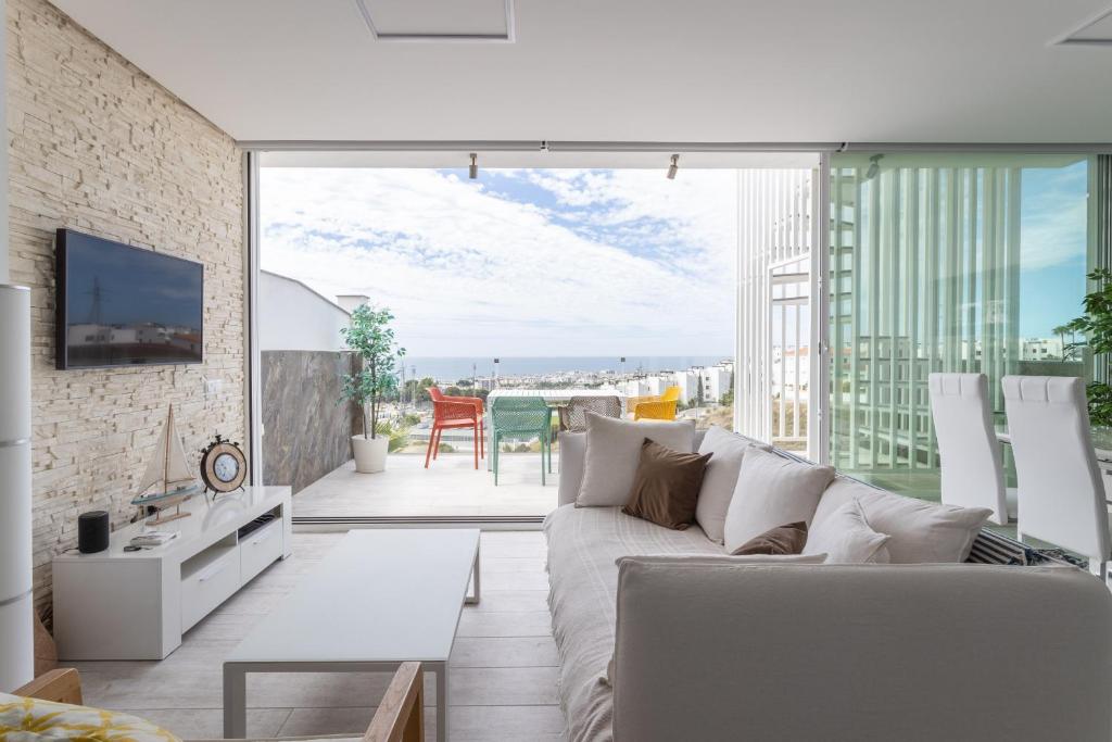 a living room with a couch and a large window at Nerja Luxury Apartment in Nerja