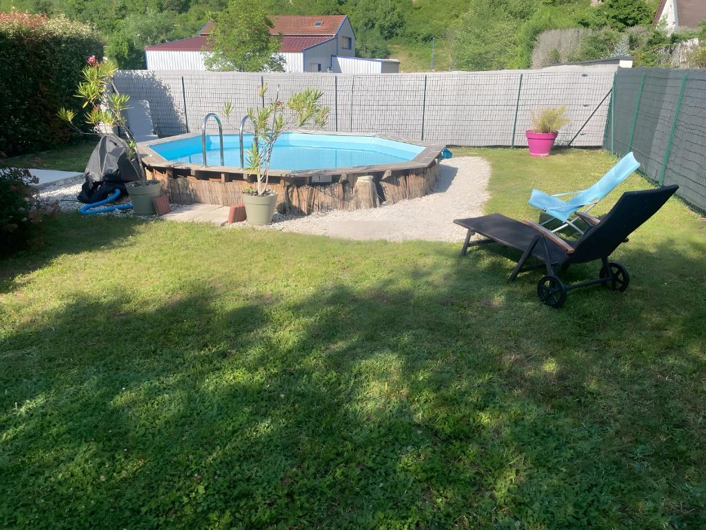 a chair in a yard next to a swimming pool at Maison de Violette in Serrières-de-Briord