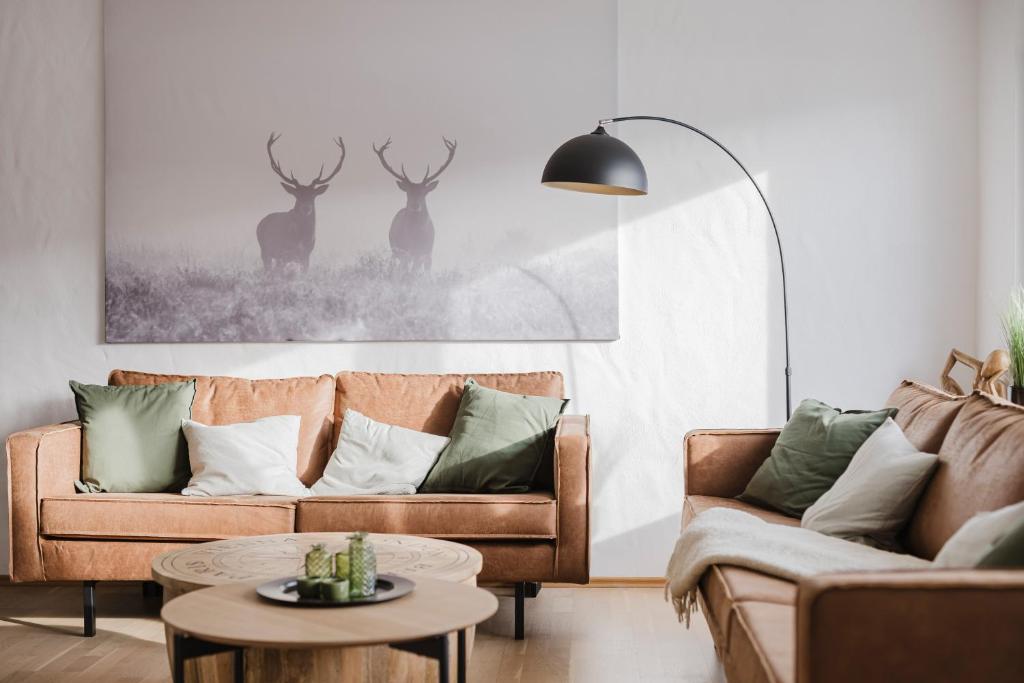 a living room with two couches and a table at Ferienwohnung Waldzauber Lennestadt in Lennestadt