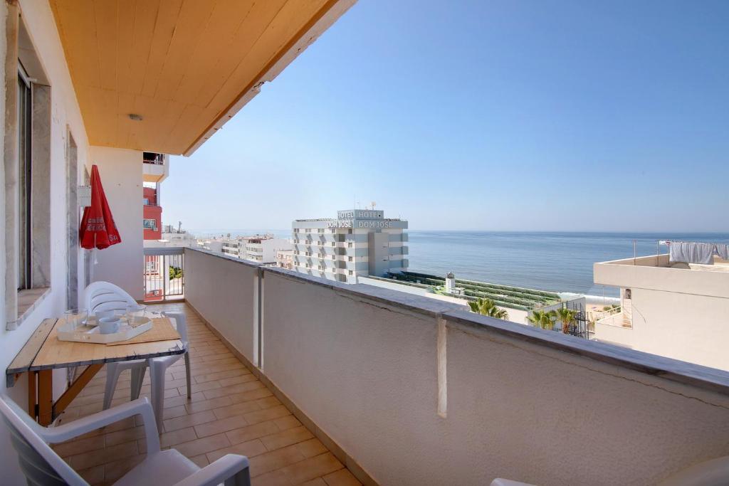 a balcony with a table and chairs and the ocean at Moderno e acolhedor com vista mar in Quarteira