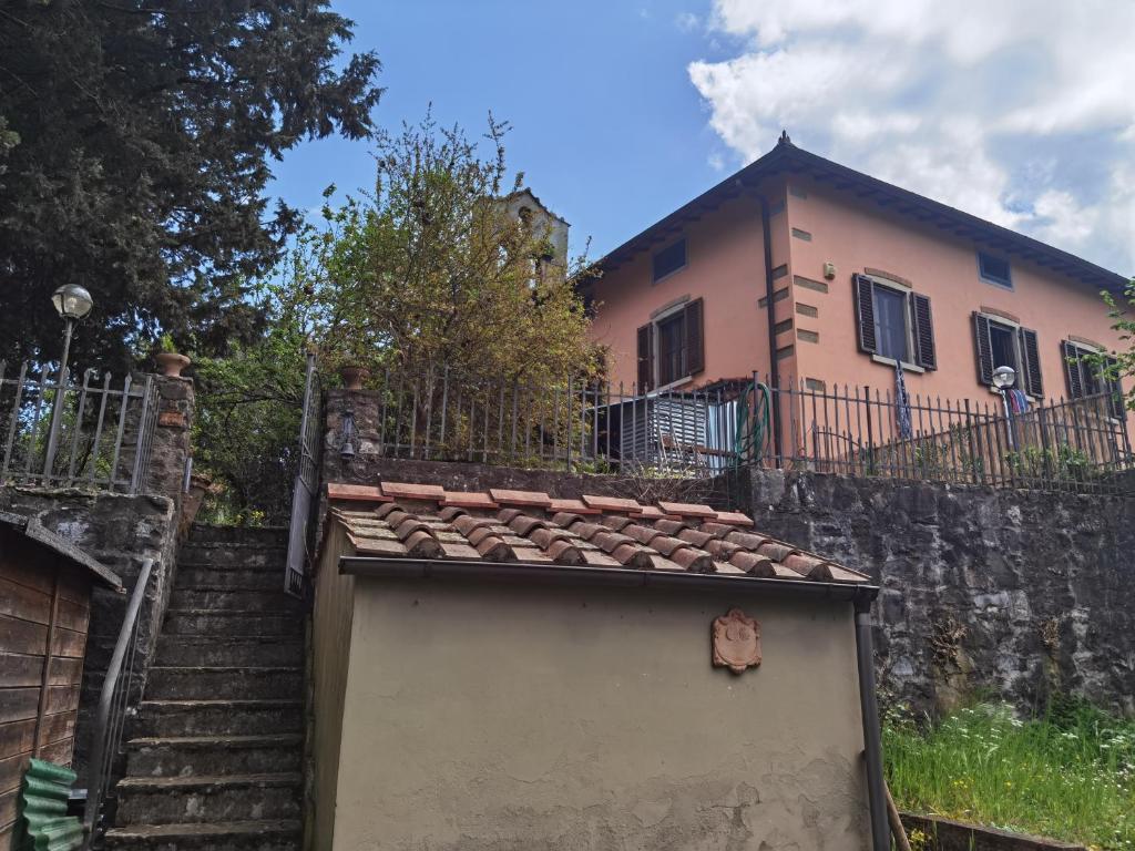 a house with a fence and stairs leading up to it at Villa Paradiso Julia in Dicomano
