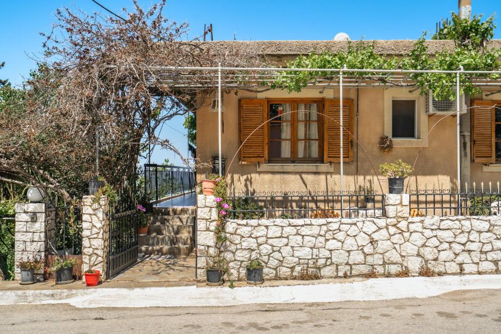 a house with a stone wall and a gate at Vangelis studio 2 in Kefalonia