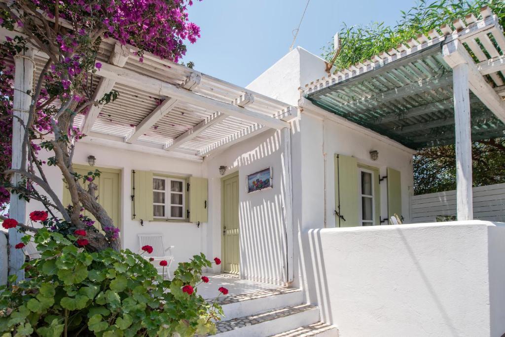 a white house with a pergola and flowers at Green Retreats 5 Paros in Isterni