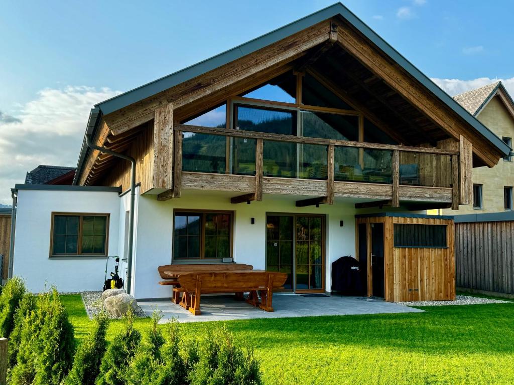 a house with a large deck and a wooden piano at Chalet Almblick mit Sauna in Tauplitz