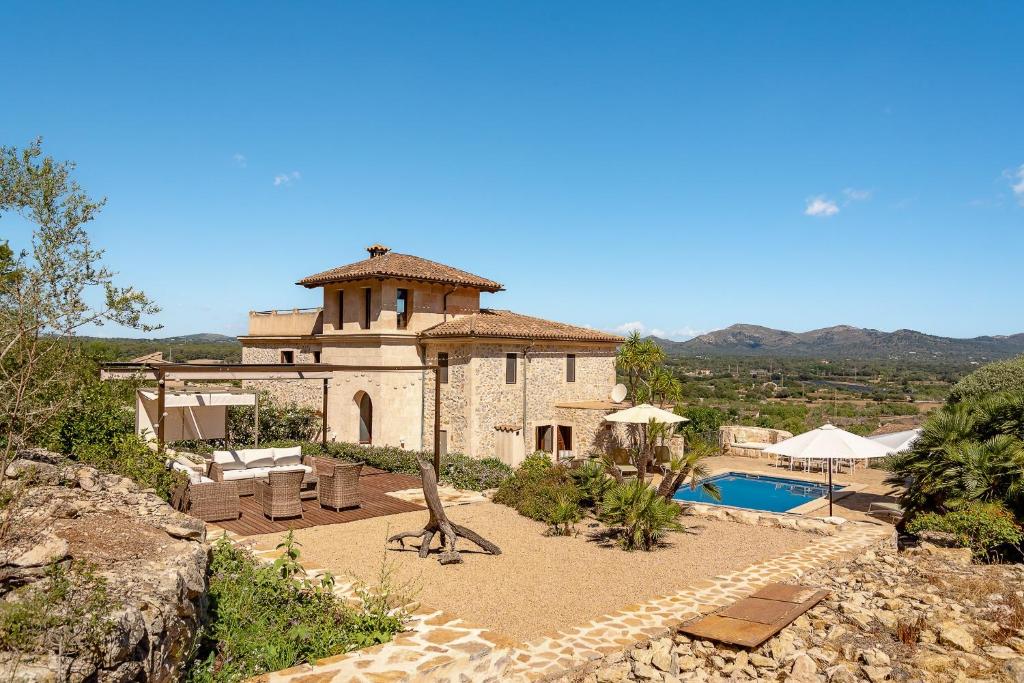 a building with a swimming pool and a house at Finca Estrella in Artá