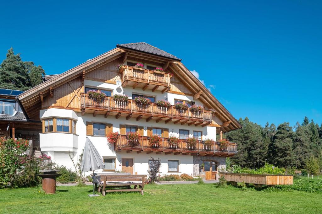 a building with balconies and a bench in front of it at Kardinerhof in Collalbo