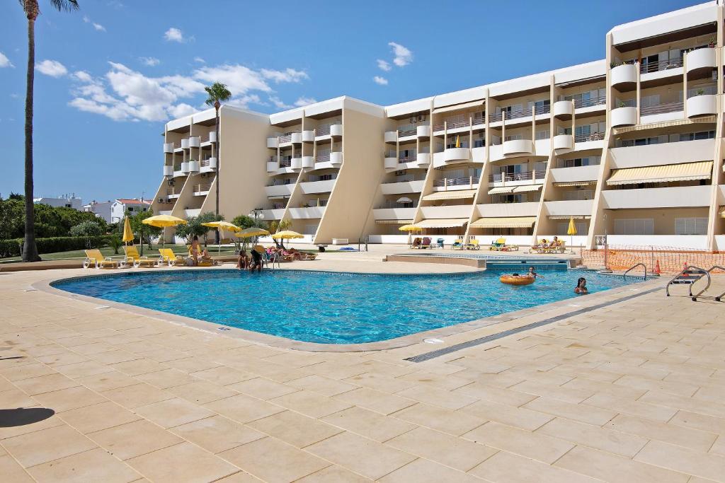 a swimming pool in front of a building at Palmeira Galé in Galé