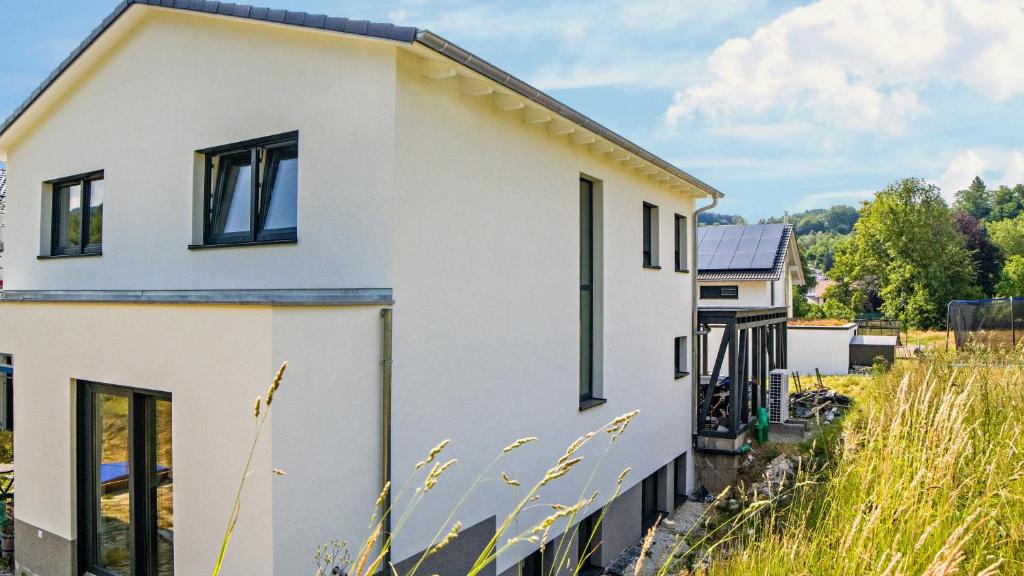 ein weißes Haus mit schwarzen Fenstern in der Unterkunft Schuttig in Elzach