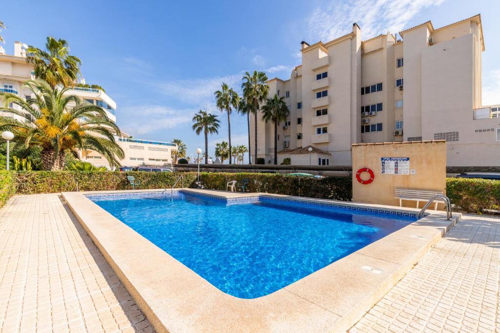 a swimming pool in front of a building at Albir Playa in Alfaz del Pi