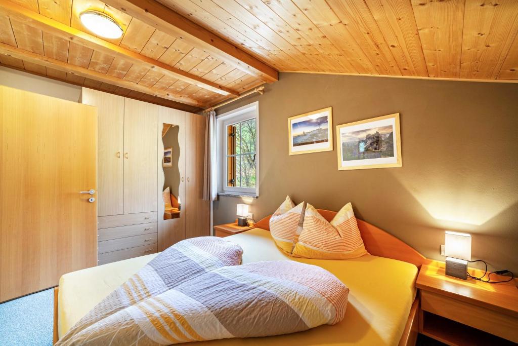 a bedroom with a bed and a wooden ceiling at Lingerhof Alpenrose in Meltina