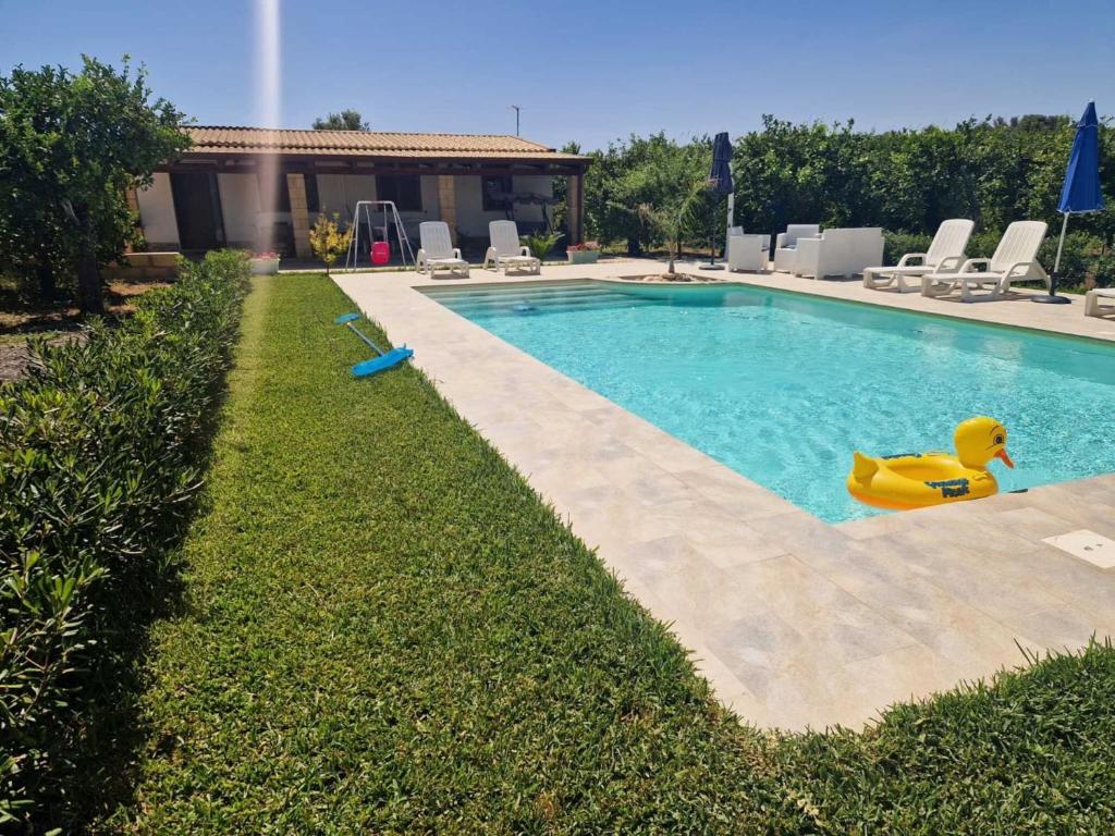a swimming pool with a yellow toy in the grass at Villa Lorenzo in Avola