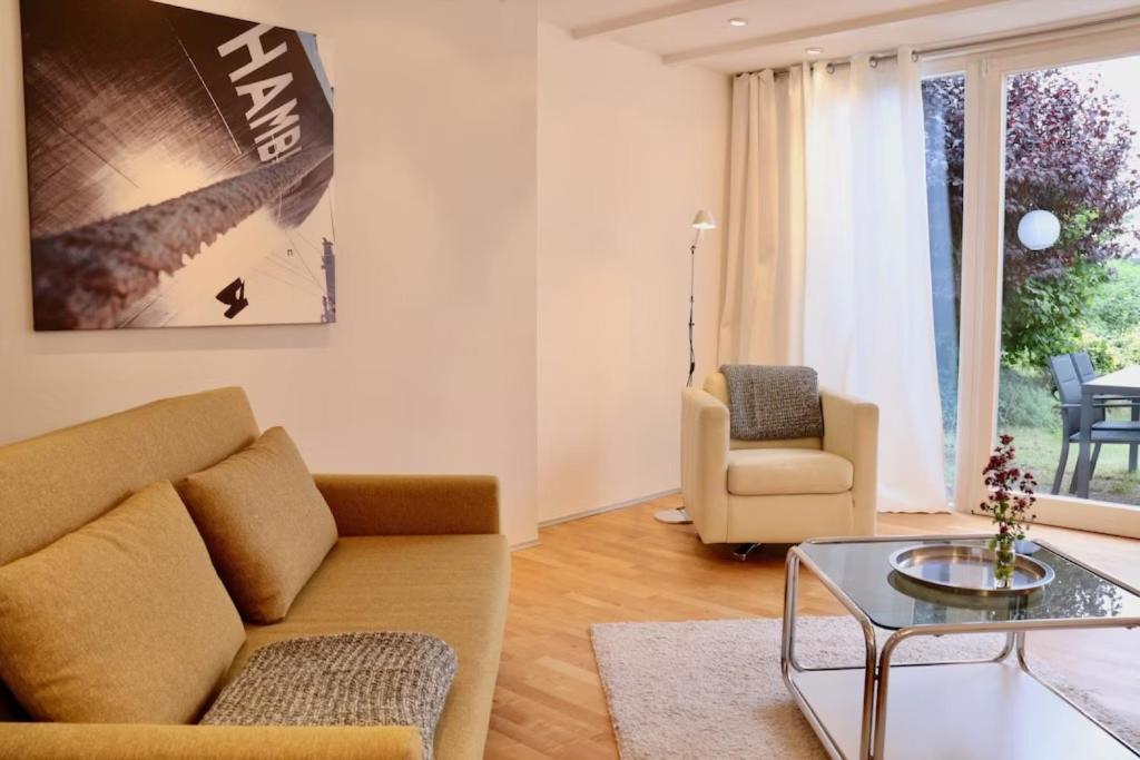 a living room with a couch and a glass table at Tiny Haus an der Schlei in Kosel