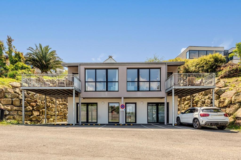 a house with a car parked in front of it at Les Terrasses de la Palud in Landéda