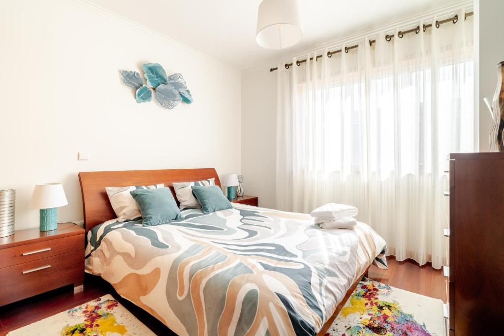 a bedroom with a bed with a zebra printed bedspread at Lagoa Residence in Esposende