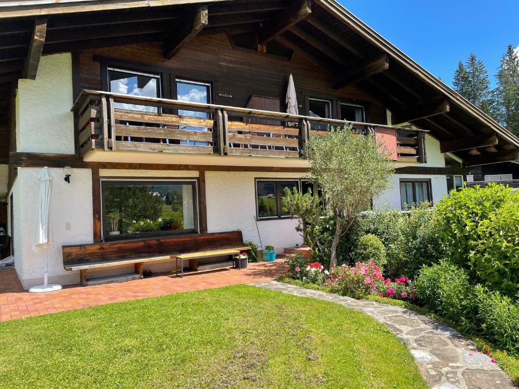 a house with a bench in front of it at Fewo 1 am Auweg in Hirschegg