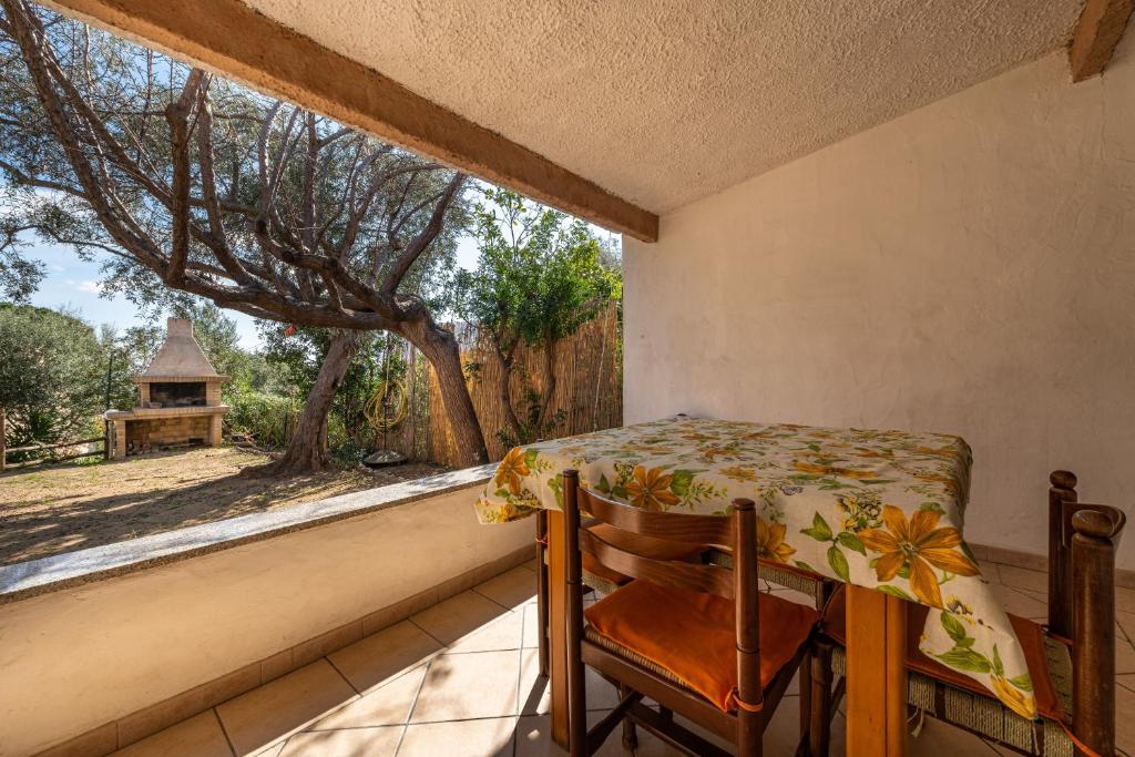 a table and a chair on a balcony with a window at Villa Martina in Costa Rei