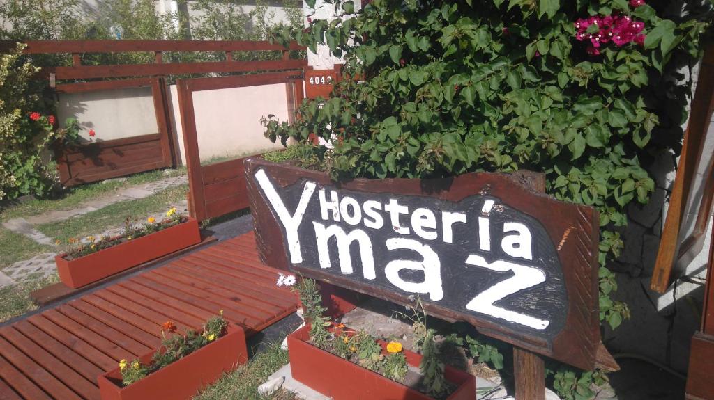 Un cartello che dice: Victoria Mai vicino a qualche pianta. di Hosteria Ymaz a Villa Gesell