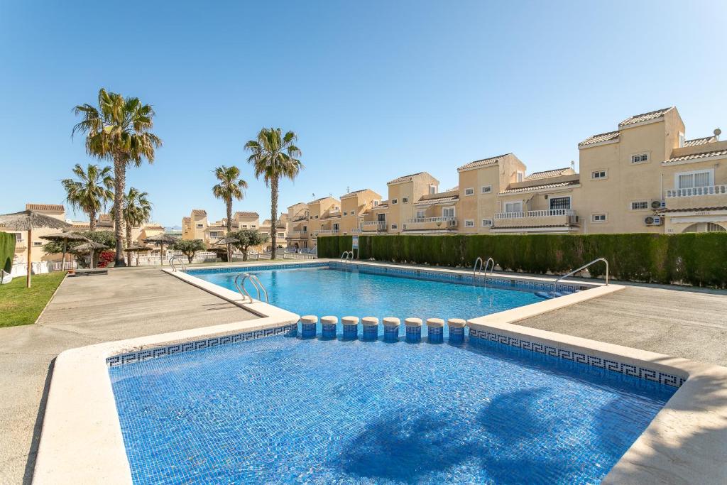 a large swimming pool with palm trees and buildings at Bungalow Desired Track in Santa Pola