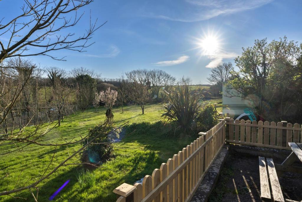 a backyard with a wooden fence and a field at finest Retreats - Trimstone Manor, Lee Studio Apartment in Woolacombe