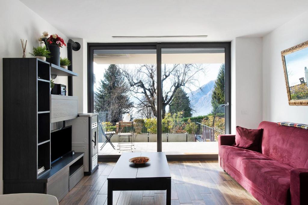 a living room with a red couch and a large window at La Grande Bellezza in Perledo