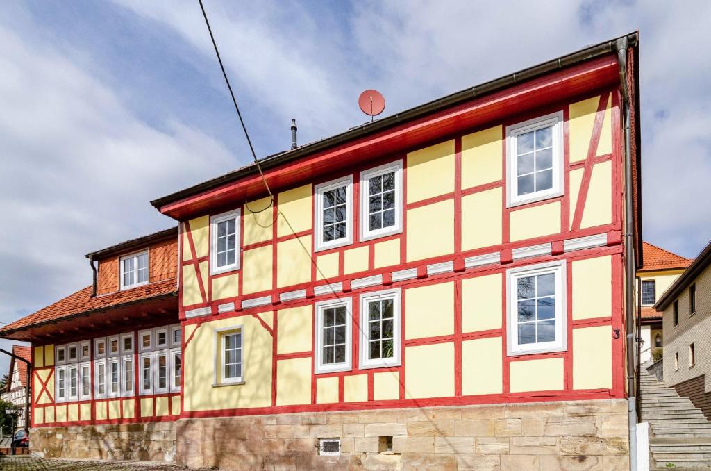 a yellow and orange building with white windows at Ferienwohnung am West-östlichen Tor in Ecklingerode