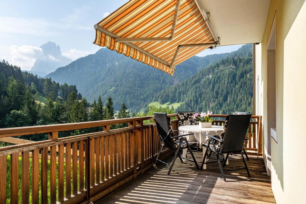 a balcony with a table and chairs and mountains at Salman in Ortisei