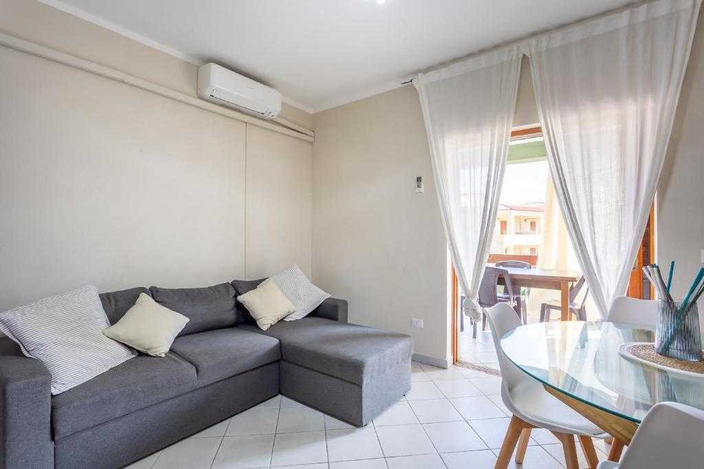 a living room with a couch and a glass table at Casamorle in Isola Rossa