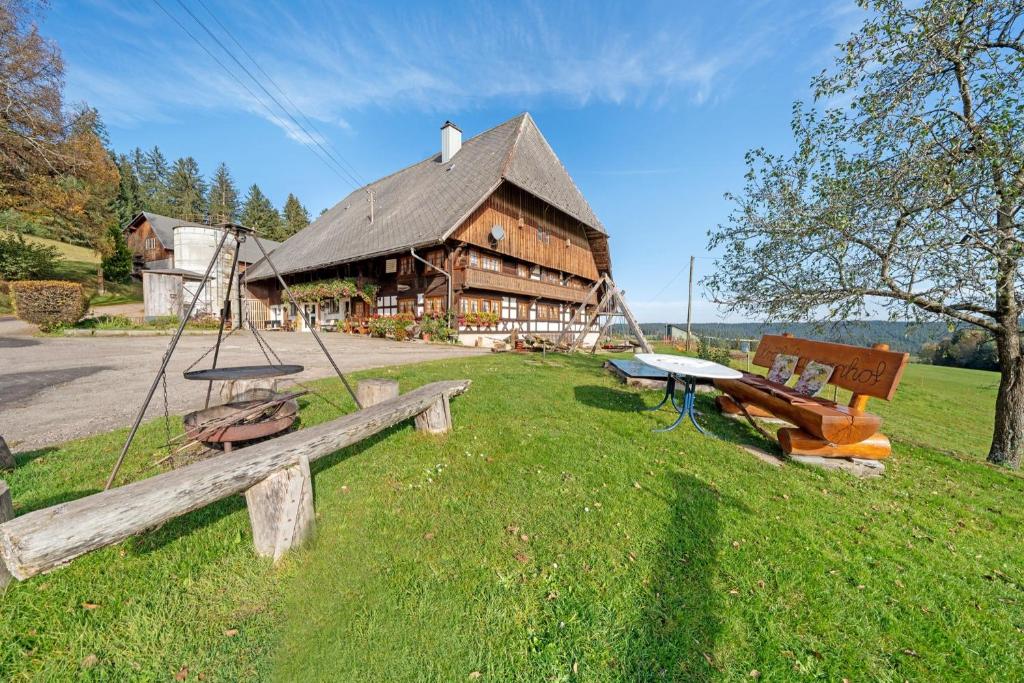 a large wooden building with a bench in front of it at Krährbauernhof mit Hofladen in Hornberg