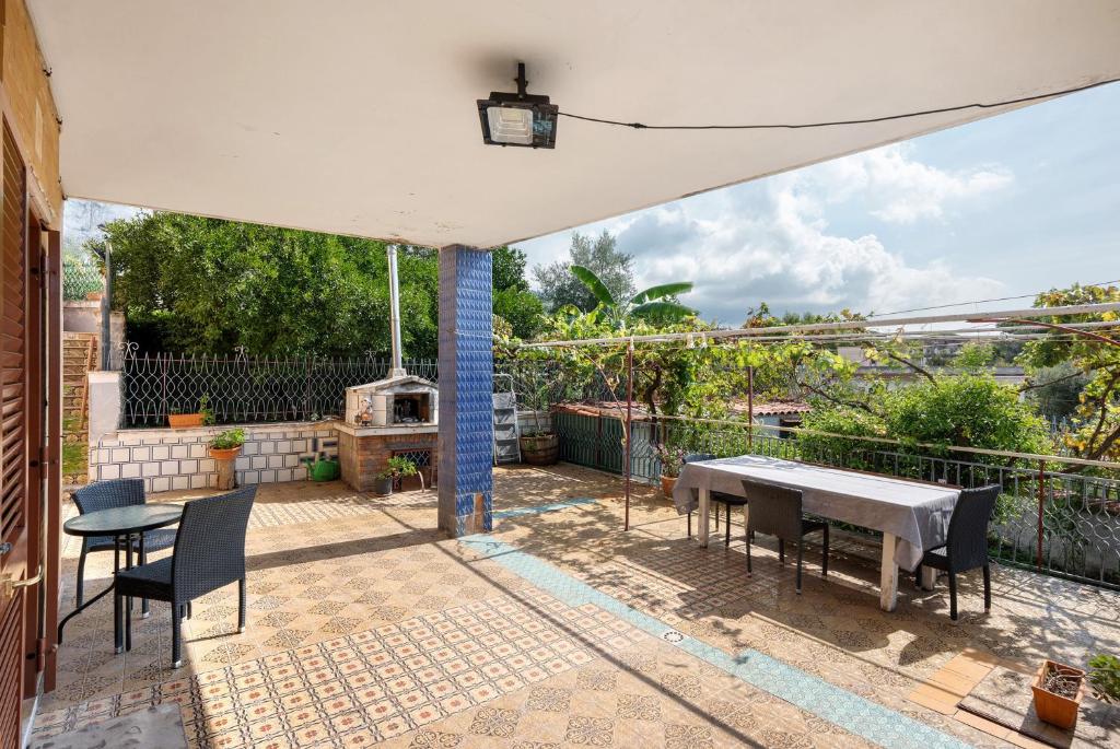 a patio with a table and chairs and a grill at Holidayshouse in Ercolano