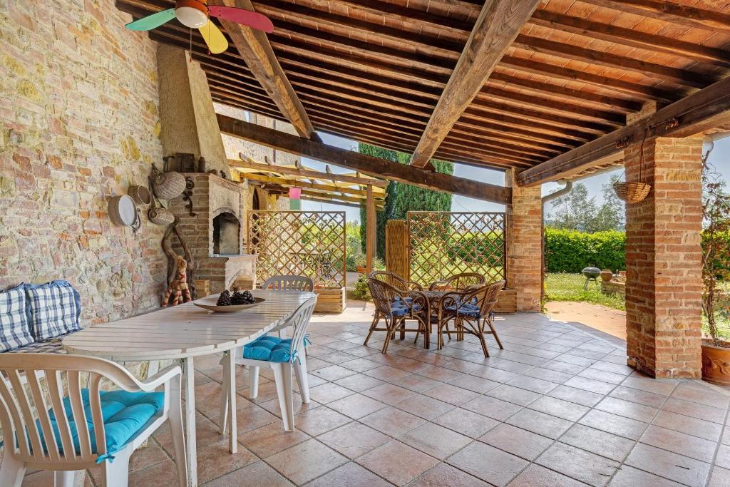 a patio with a table and chairs and a brick wall at La Ripa - Appartamento Padronale in San Gimignano