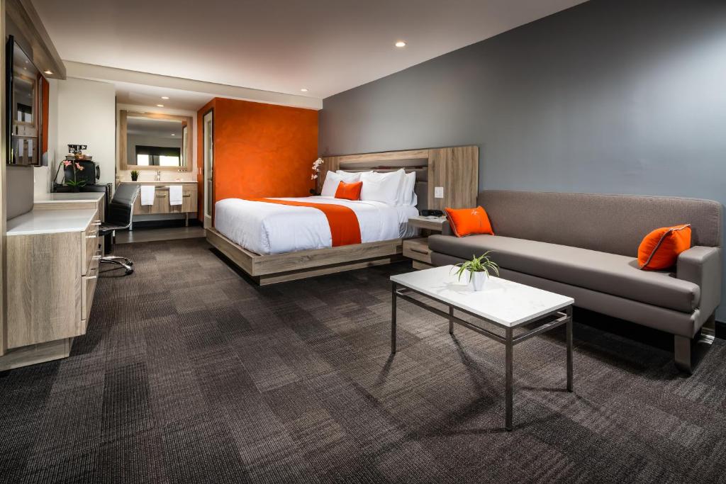 ein Hotelzimmer mit einem Bett und einem Sofa in der Unterkunft Canoga Hotel at Warner Center in Canoga Park