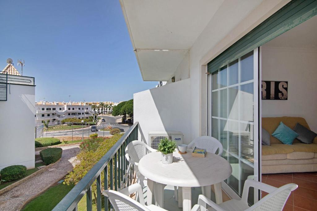 a balcony with a white table and chairs and a couch at Algarvio ao Sol in Conceição