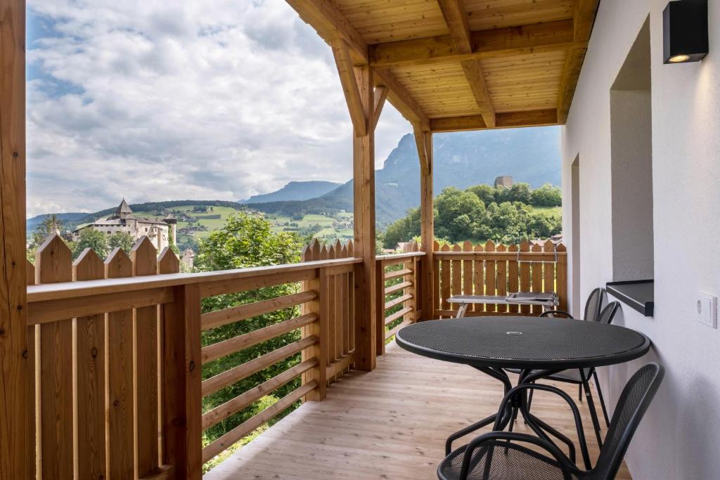 a balcony with a table and chairs and a view at Rotkäppchen Schlosshof in Völs am Schlern