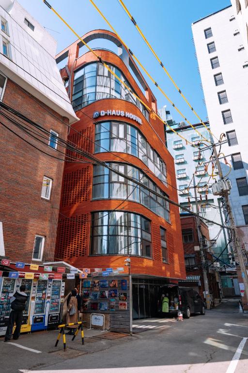 a red building with people standing in front of it at D-Haus Hostel Dongdaemun in Seoul