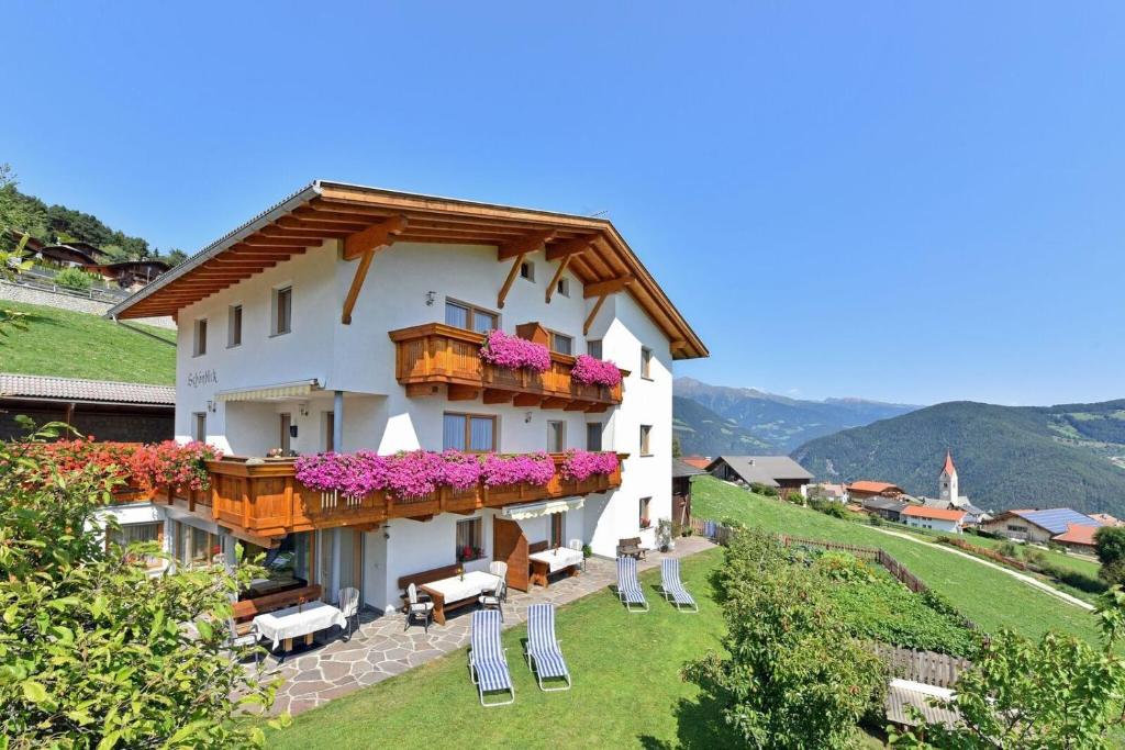 a building with a balcony with flowers on it at Apartment Pustertal in Mühlbach