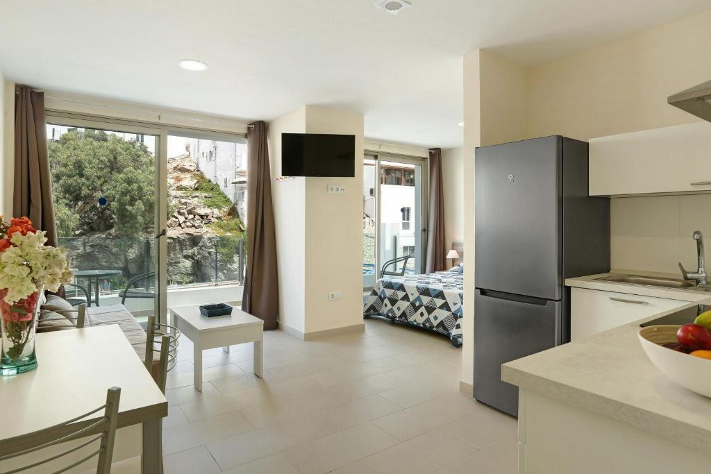 a kitchen and living room with a view of a balcony at Albamar 1d in Puerto de Mogán
