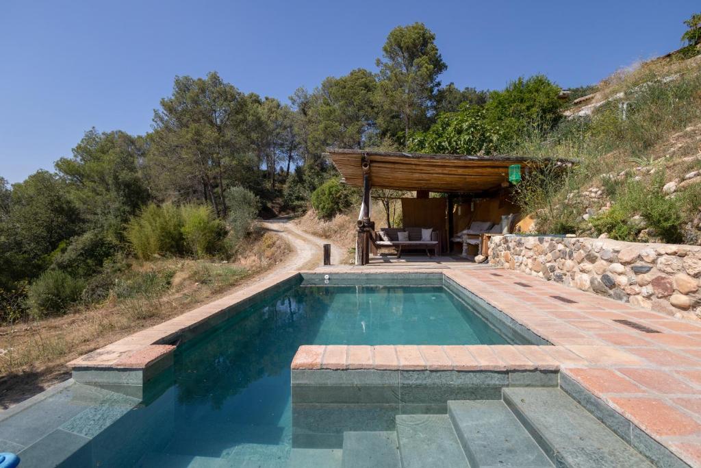 a swimming pool in the middle of a hill at La Isla Verde in Els Hostalets