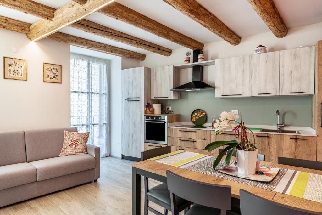 a kitchen and living room with a table and a couch at L'antica corte apt Angelina in Levico Terme