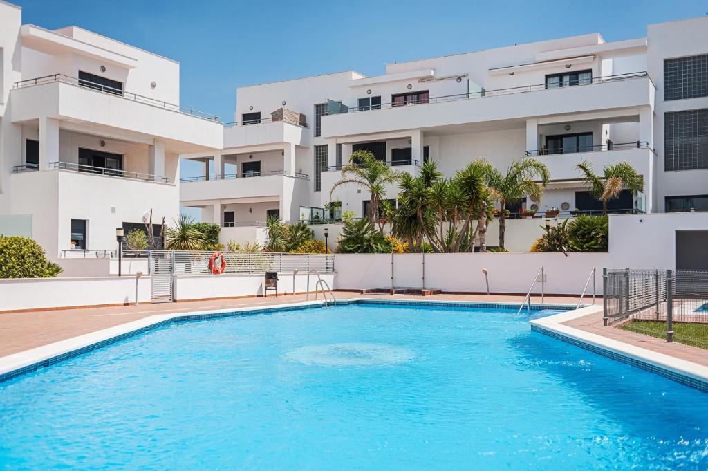 a swimming pool in front of a building at Apartamento Cañada Honda Conil in Conil de la Frontera