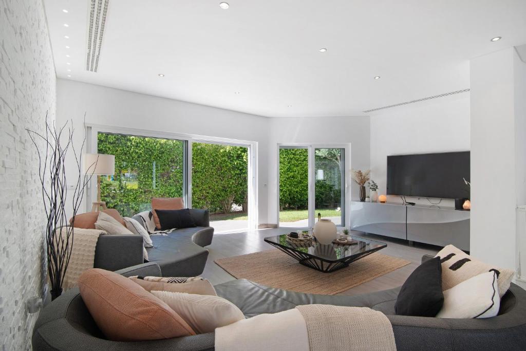 a living room with couches and a flat screen tv at Pine Lodge in Vilamoura